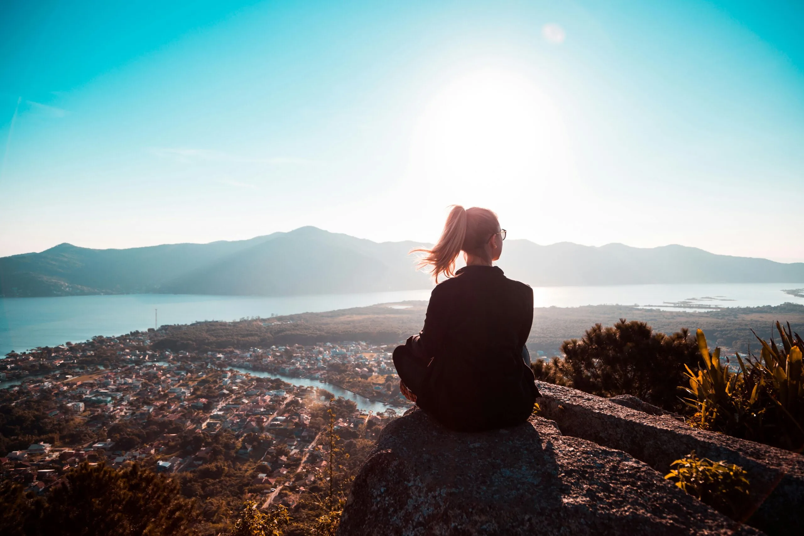 A woman sitting on a mountain thinking am i experiencing family trauma