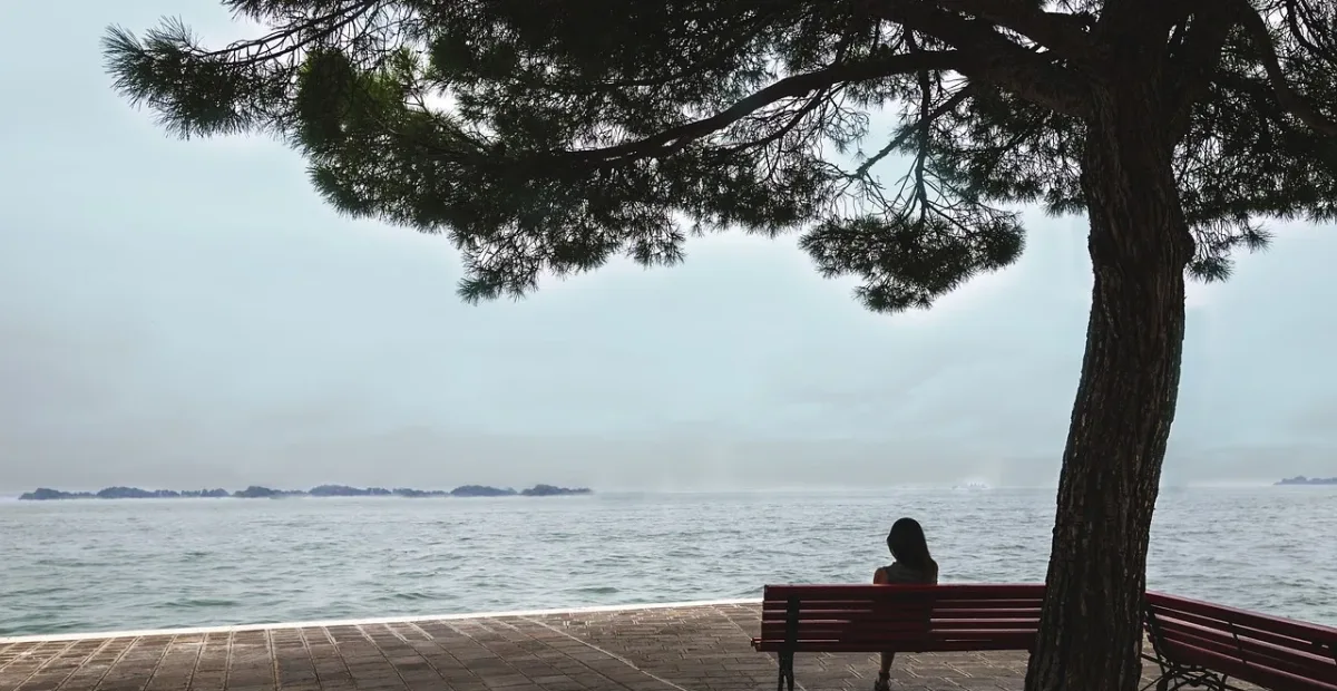 woman sitting by water thinking about her options for setting boundaries with her parents